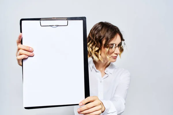 Geschäftsfrau mit einem Ordner weißer Dokumente in der Hand auf hellem Hintergrund und Frisur Brillenmodell — Stockfoto