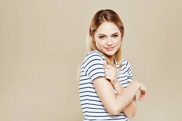 Cute blonde striped t-shirt smile lifestyle beige studio background — Stock Photo, Image