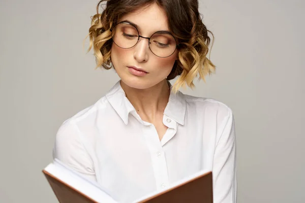 Zakelijke vrouw met notitieblok en bril op een lichte achtergrond kapsel succes emoties — Stockfoto