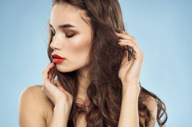 Zarif esmer, modaya uygun, parlak, makyajlı, çıplak omuzlar yakın plan, mavi arka plan.