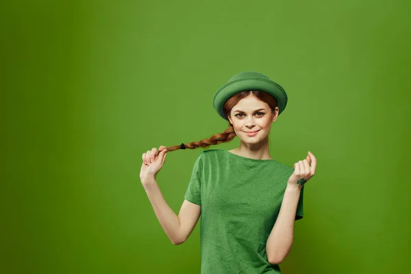 Donna felice con trifoglio il giorno di San Patrizio in abiti verdi e un cappello sulla testa gesticolando con le mani — Foto Stock