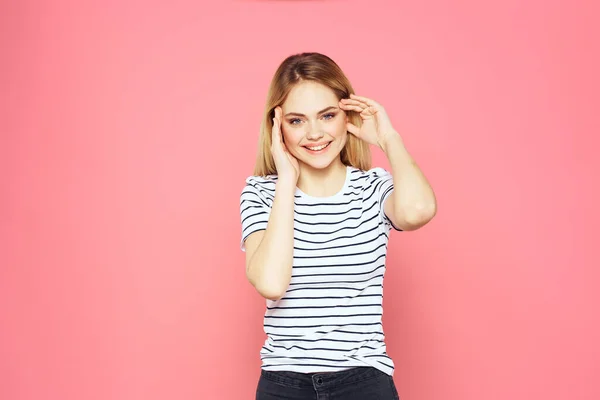 陽気女性ストライプtシャツライフスタイル感情やジェスチャーで手ピンクの背景 — ストック写真