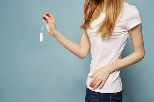 Mujer con tampón y jeans camiseta menstruación fondo azul recortado ver higiene —  Fotos de Stock