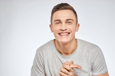 Neşeli, duygusal, gri tişörtlü, el hareketli stüdyo yaşam tarzı.