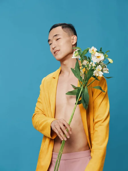 黄色のコートと白い花の若い男青の背景 — ストック写真