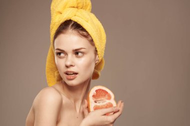 Kafasında sarı havluyla güzel bir kadın egzotik meyveli narenciye vitaminleri.