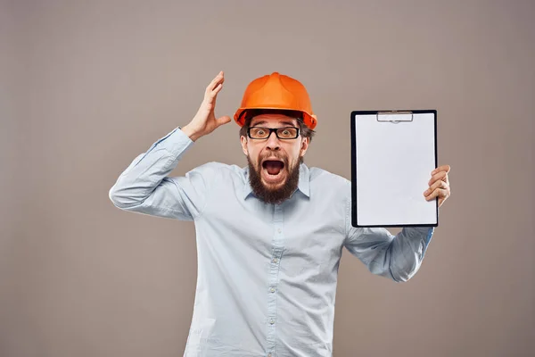 Мужчина в рубашке с оранжевой шляпной инженер работает документы оказания услуг — стоковое фото