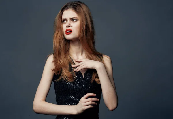 Portrait d'une femme en robe noire gesticulant avec des émotions de maquillage lumineux avec ses mains — Photo