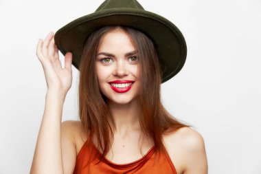 Şapkalı bir kadının portresi. Yüzüne yakın bir el gülümse. Seksi görün. 