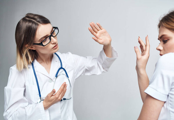 Nurse and patient gestures with hands light background stethoscope disease