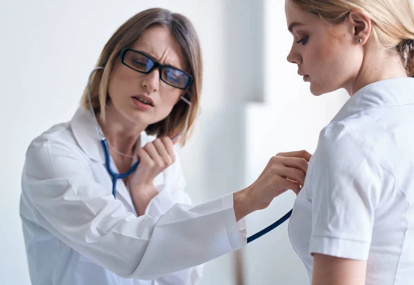 Medico e paziente su sfondo azzurro stetoscopio problemi di salute vista ritagliata — Foto Stock