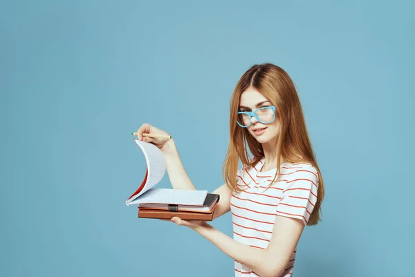Girl in fashionable glasses with notebooks in hands on a blue background cropped view Copy Space — Stock Photo, Image