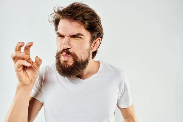 Бородатий чоловік жестикулює руками обрізаний вид біла футболка студійний емоційний світлий фон — стокове фото