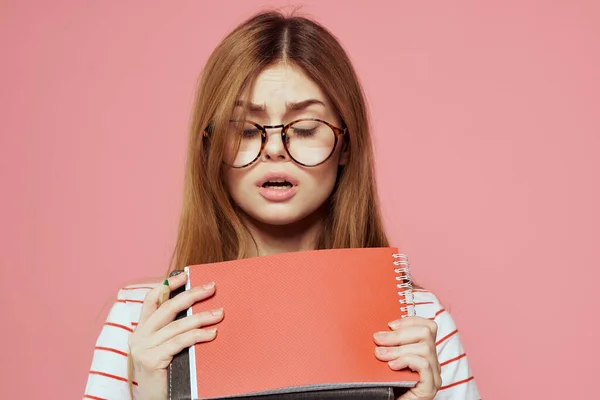 Молодая студентка с книгами на розовом фоне в очках в институте лицевого образования обрезанный вид — стоковое фото