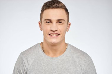 Gri tişörtlü yakışıklı adam duygu stüdyosu modelini kesmiş.