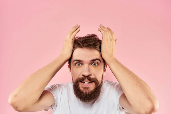 Бородатий чоловік у білій футболці жестикулює руками вираз обличчя крупним планом рожевий фон — стокове фото
