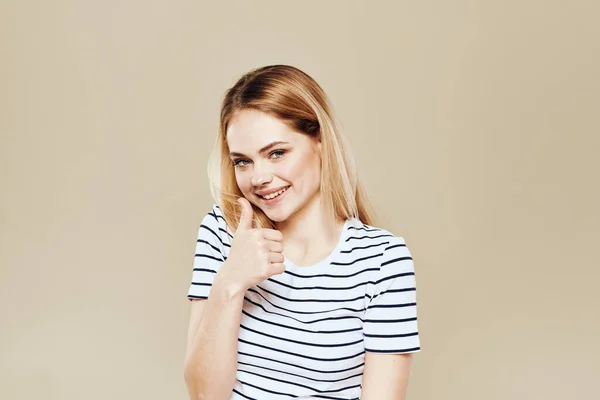 可愛いですブロンドストライプTシャツ笑顔ライフスタイルベージュスタジオの背景 — ストック写真