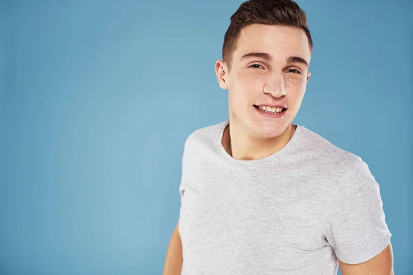 Emotionele man in wit t-shirt bijgesneden uitzicht op blauwe achtergrond levensstijl — Stockfoto