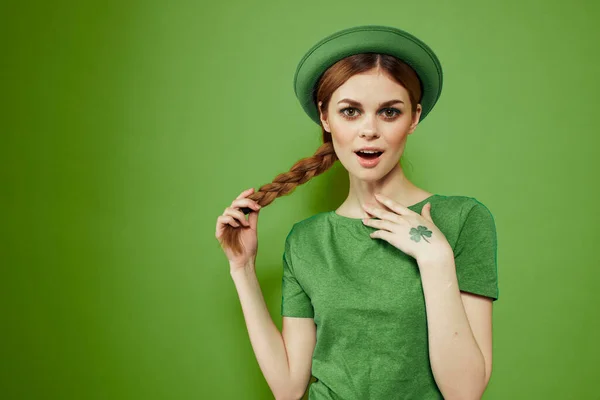 Belle fille avec un trèfle sur sa main sur un fond vert vacances St. Patricks Day chapeau amusant sur sa tête — Photo