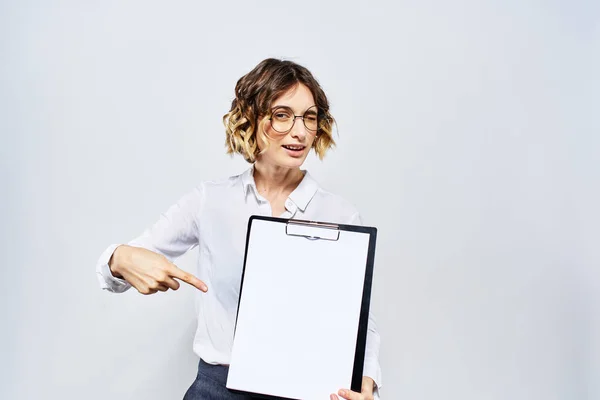 Geschäftsfrau mit einem Ordner weißer Dokumente in der Hand auf hellem Hintergrund und Frisur Brillenmodell — Stockfoto