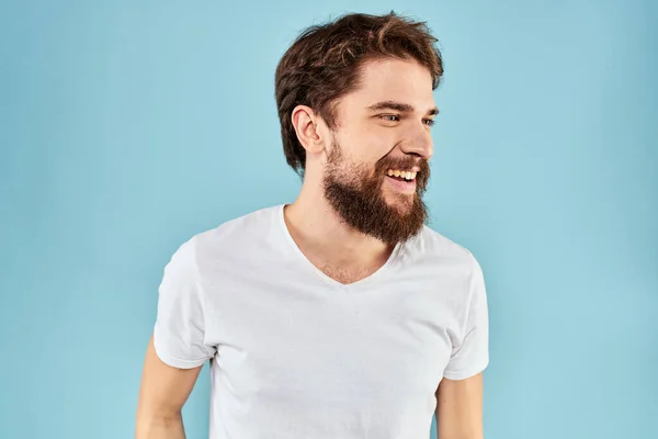 Uomo emotivo con la barba in una t-shirt bianca sfondo blu stile di vita divertente — Foto Stock