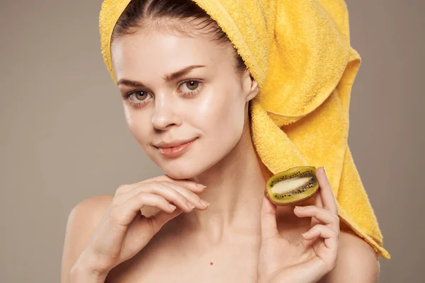 Wanita ceria dengan handuk di kepala dan tangan kulit perawatan bahu telanjang beige latar belakang — Stok Foto