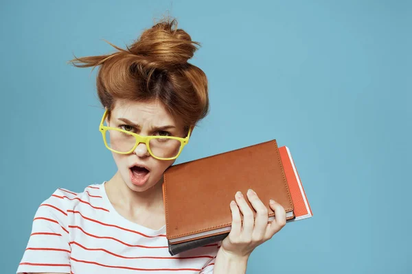 Estudante feminina com blocos de notas e óculos penteado em sua cabeça professor modelo azul fundo — Fotografia de Stock