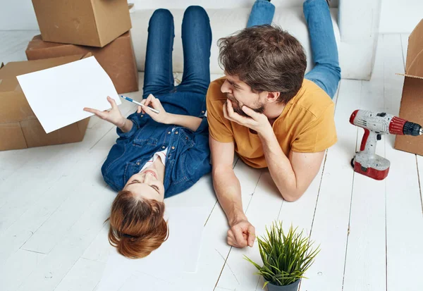 Άντρας και γυναίκα στο πάτωμα με κουτιά που σχεδιάζουν να μετακομίσουν στο διαμέρισμα — Φωτογραφία Αρχείου