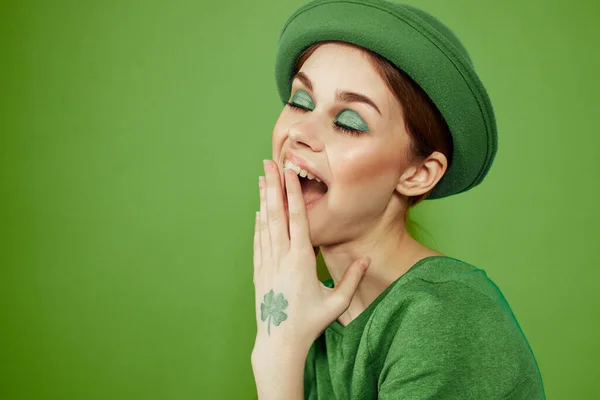 Belle fille avec un trèfle sur sa main sur un fond vert vacances St. Patricks Day chapeau amusant sur sa tête — Photo