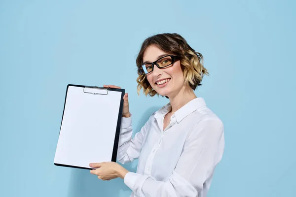 Деловая женщина с документами в папке на синем фоне и в светлых очках на лице — стоковое фото