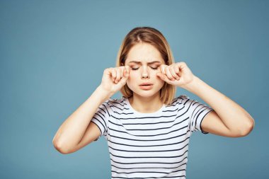 Çizgili tişört giyen bir kadın. Kırpılmış manzara. Mavi izole edilmiş arka plan.