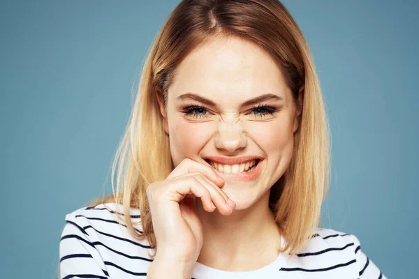 Blond meisje in gestreept t-shirt lifestyle blauw achtergrond plezier — Stockfoto