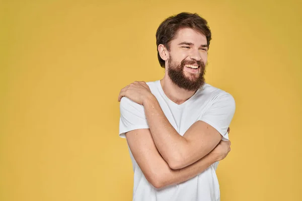 Barbudo hombre en emociones blanco camiseta divertido estilo de vida amarillo fondo — Foto de Stock