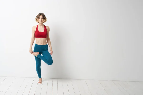 Seorang wanita dalam pertumbuhan penuh Di kamar yang cerah yoga meditasi terlibat dalam olahraga — Stok Foto