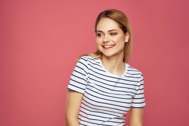 Neşeli kadın çizgili tişörtlü yaşam tarzı duyguları ve elleri pembe arka planlı jestler.