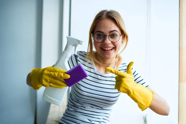 Cheerful cleaning lady in rubber gloves cleaning tools interior service