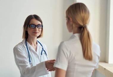 Hasta, arka planda steteskopla doktora geldi.