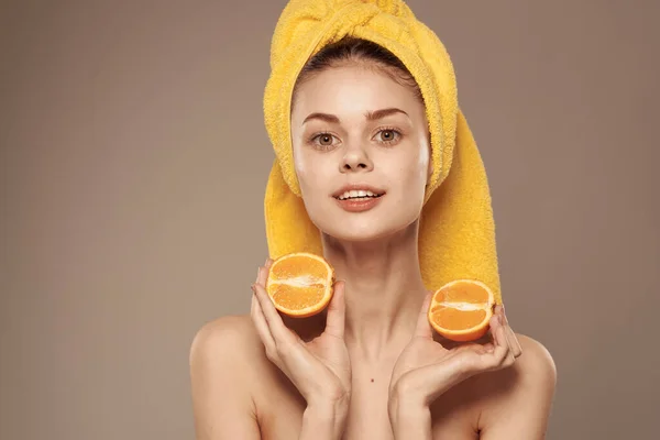 Mulher com ombros desnudados laranjas em mãos limpar a saúde da pele bege fundo — Fotografia de Stock