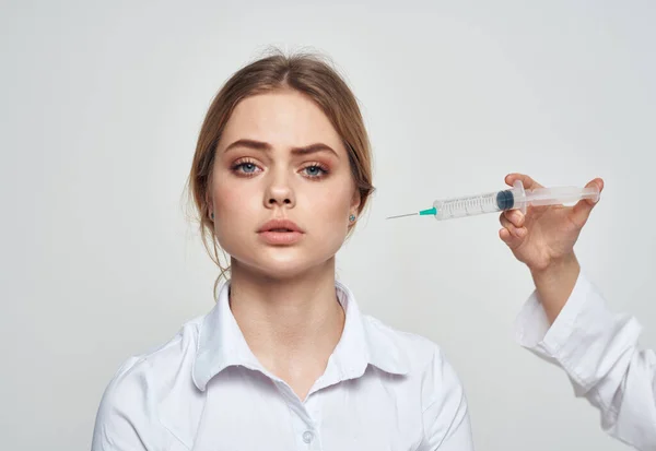 Jeringa con líquido y una paciente con una camiseta blanca problemas de salud — Foto de Stock