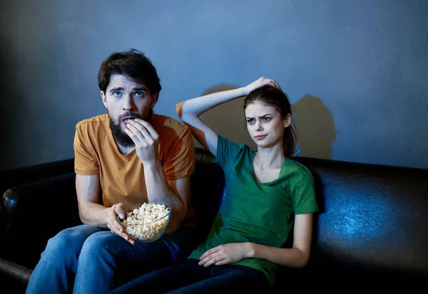 En el sofá y una mujer bonita está viendo programas de televisión — Foto de Stock