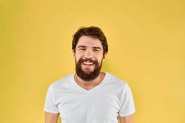 Un uomo in una t-shirt bianca gesti con le mani stile di vita ritagliato vista giallo sfondo più divertente — Foto Stock