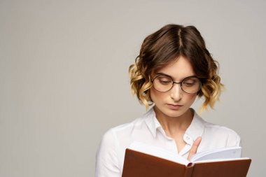 Hafif arka planda gözlüklü, not defteri olan iş kadını saç stili başarısı duyguları.