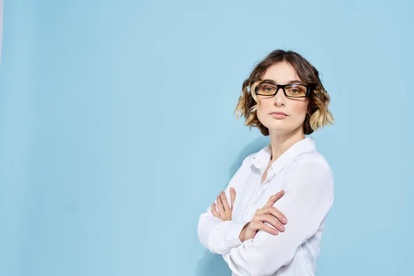 Geschäftsfrau auf blauem Hintergrund Brille mit dunklem Rand lockiges Haar Helles Hemd abgeschnittene Ansicht — Stockfoto