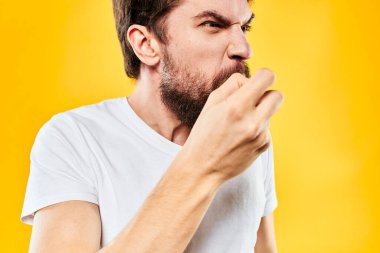 El kol hareketleri yapan sakallı bir adam stüdyo yaşam tarzı hoşnutsuz sarı arka plan