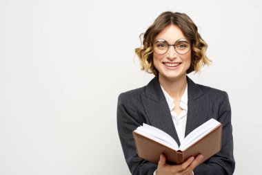 El fenerindeki kitapla çalışan kadın klasik takım elbiseli gözlüklü kafa.