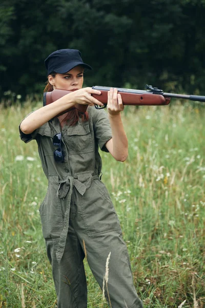 그의 앞에서 총을 든 여자가 초록색으로 사냥하는 것을 목표로 삼고 있습니다 — 스톡 사진