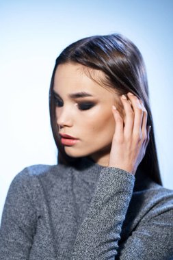 Güzel esmer, parlak makyajlı. Yakından çekici görünüyor.