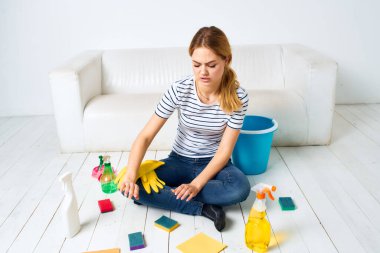 Odadaki temizlikçi kadın aksesuarları yıkıyor.