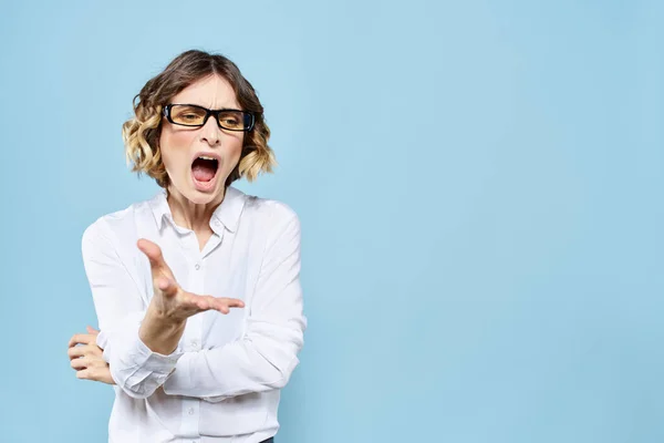 Üzleti nő egy könnyű póló egy kék háttér gesztusok kezével érzelmek modell munka — Stock Fotó