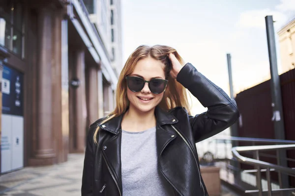 Szczęśliwa kobieta modelka w skórzanej kurtce idzie ulicą — Zdjęcie stockowe
